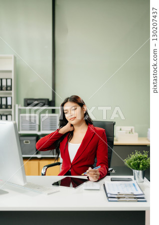 Overworked young Asian businesswoman office worker suffering from neck pain after had a long day Overworked young Asian businesswoman office worker suffering from neck pain after had a long day 130207437