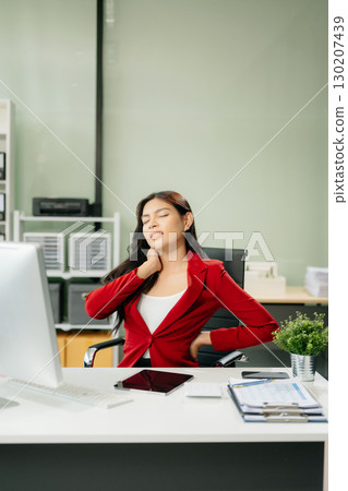 Overworked young Asian businesswoman office worker suffering from neck pain after had a long day Overworked young Asian businesswoman office worker suffering from neck pain after had a long day 130207439