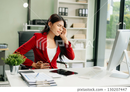 Overworked young Asian businesswoman office worker suffering from neck pain after had a long day 130207447
