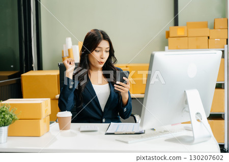 Business woman are delighted and happy with the work they do on their tablet, laptop and taking notes 130207602