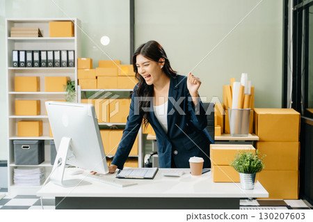 Young business owner woman prepare parcel box and standing check online orders for deliver to customer Young business owner woman prepare parcel box and standing check online orders for deliver to customer 130207603