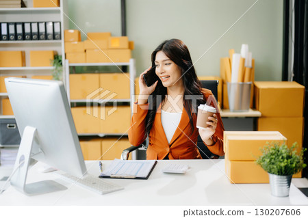 Young business owner woman prepare parcel box and standing check online orders for deliver to customer 130207606