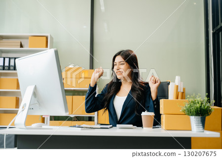 Young business owner woman prepare parcel box and standing check online orders for deliver to customer 130207675