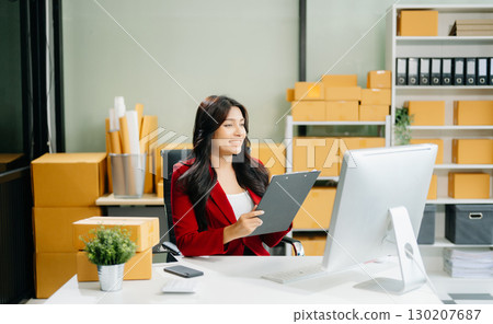 Woman Entrepreneur: SME Business mastering e-commerce with tablet, laptop, packaging, 130207687