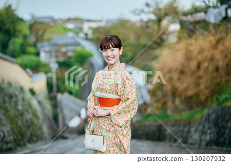 一位身著和服的女子漫步在城下町 130207932