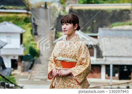 一位身著和服的女子漫步在城下町 130207941