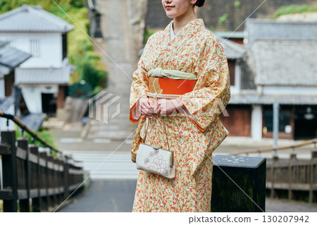 A woman in a kimono strolling through the castle town 130207942