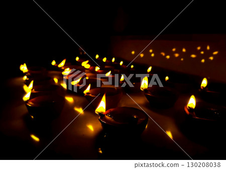 Rows of Lit Clay Oil Lamps Creating Warm Festival Glow 130208038