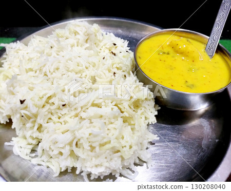 Traditional Indian Kadhi with Steamed Rice Served in Steel Plate Traditional Indian Kadhi with Steamed Rice Served in Steel Plate 130208040