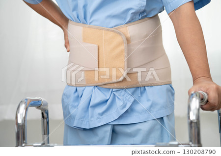 Asian senior pain back wearing elastic support belt with walker. 130208790