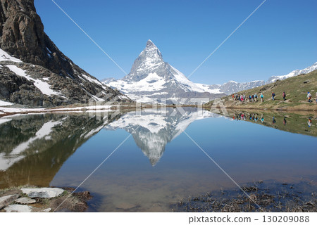 The Matterhorn's snow and perpetual snow reflected on the surface of Lake Riffel in midsummer at Zermatt, Switzerland - Standard shot from the lakeside The Matterhorn's snow and perpetual snow reflected on the surface of Lake Riffel in midsummer at Zermatt, Switzerland - Standard shot from the lakeside 130209088