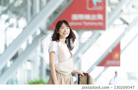站在機場入口處的旅行婦女 站在機場入口處的旅行婦女 130209347