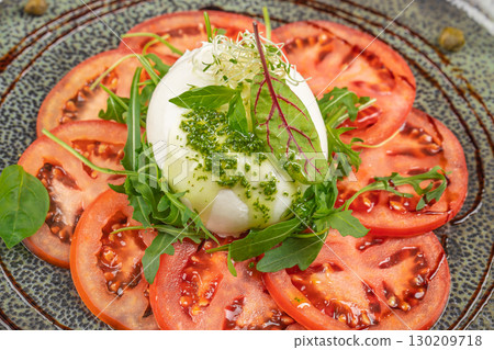 Fresh caprese salad with mozzarella, sliced tomatoes, arugula, and pesto sauce Fresh caprese salad with mozzarella, sliced tomatoes, arugula, and pesto sauce 130209718