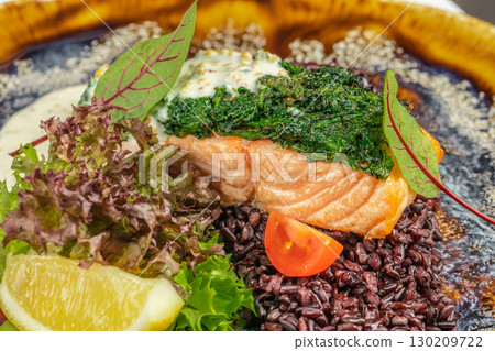 Grilled salmon fillet with spinach topping, black rice, lemon, and fresh salad Grilled salmon fillet with spinach topping, black rice, lemon, and fresh salad 130209722