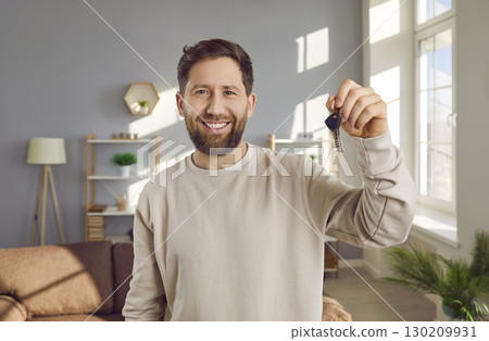 Portrait of a young happy smiling attractive man with keys in his hands. Portrait of a young happy smiling attractive man with keys in his hands. 130209931