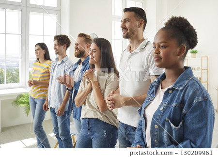 Team of joyful modern startup colleagues listen attentively to leader at meeting. 130209961