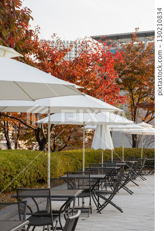Outdoor seating and umbrella with autumn foliage at Dongdaemun History and Culture Park, near Dongdaemun Design Plaza or DDP. In Seoul, South Korea 130210834