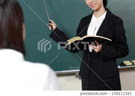 Asian female teacher teaching in front of the blackboard 130211381