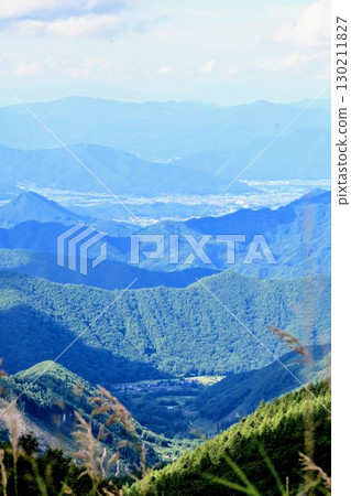 層層疊疊的夏日山脈和遠處的城市景觀 層層疊疊的夏日山脈和遠處的城市景觀 130211827