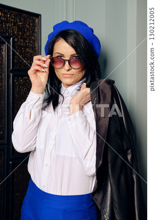 Fashionable woman posing indoors with stylish accessories and a chic outfit 130212005