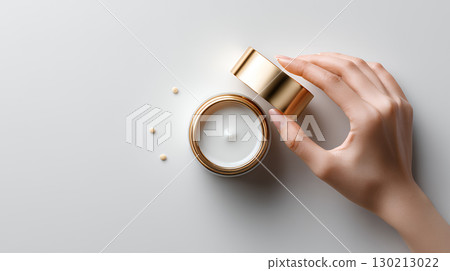 female hand holding cream bottle of lotion female hand holding cream bottle of lotion 130213022