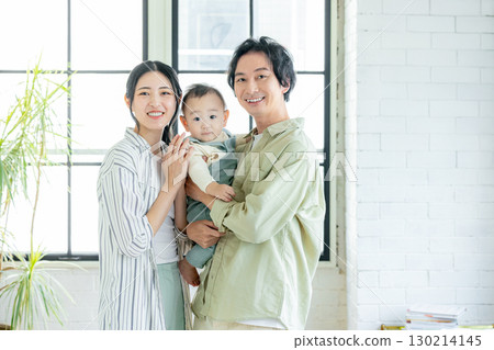 Smiling family holding a baby Smiling family holding a baby 130214145
