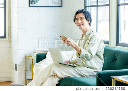 A man who uses a smartphone in the living room 130214168