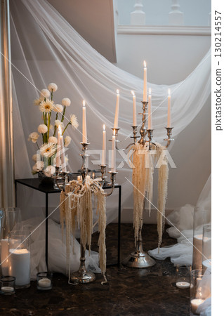 Elegant wedding reception decoration featuring silver candelabras and flowers Elegant wedding reception decoration featuring silver candelabras and flowers 130214557
