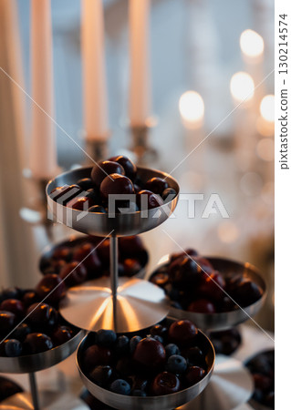 Elegant wedding reception decoration featuring tiered berries display 130214574