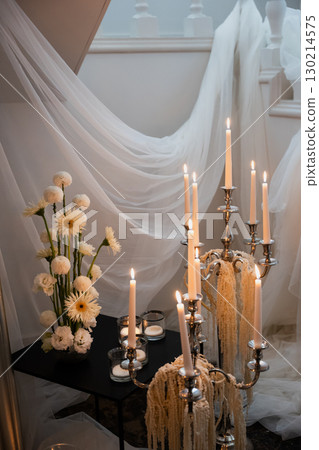 Elegant wedding reception decoration with candles, flowers, and soft drapery 130214575