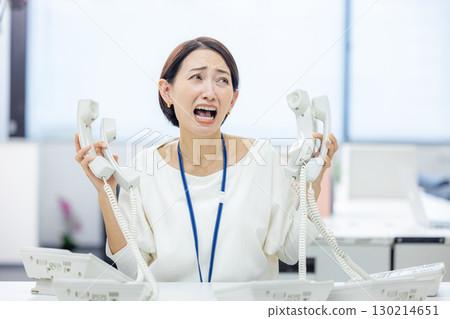 Office woman having trouble answering the phone Office woman having trouble answering the phone 130214651