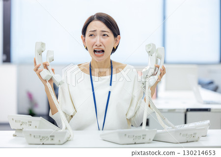 Office woman having trouble answering the phone Office woman having trouble answering the phone 130214653
