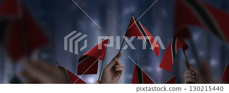 Trinidad and Tobago flags in their hands on a blurred urban background 130215440