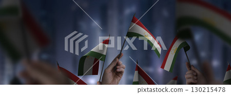Tajikistan flags in their hands on a blurred urban background Tajikistan flags in their hands on a blurred urban background 130215478