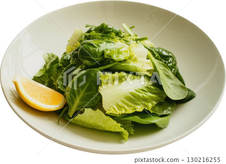Fresh garden greens salad with a vibrant lemon wedge presented in a light colored bowl 130216255