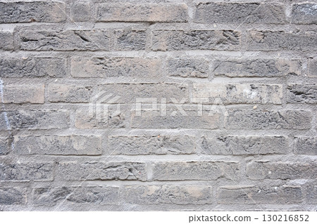 Gray structural stone wall of the ancient building consists of bricks. Nature structural background. 130216852