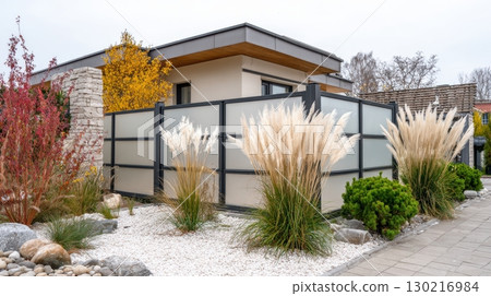 Elegant garden patio features modern architecture with ornamental grasses under an overcast sky Elegant garden patio features modern architecture with ornamental grasses under an overcast sky 130216984