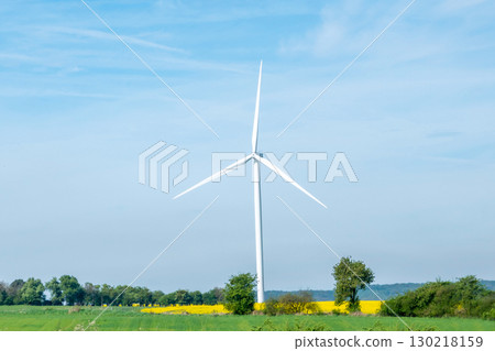 Blue sky and landscape with trees, garden, fields and wind turbine. Windmill for energy production. Green energy in Germany.  Blue sky and landscape with trees, garden, fields and wind turbine. Windmill for energy production. Green energy in Germany.  130218159