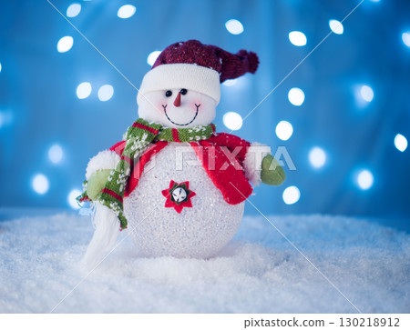 cute snowman toy on a blue background with 130218912