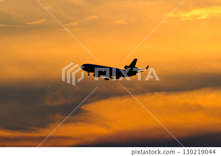 An airplane with a beautiful sunset, sky and clouds in the background 130219044