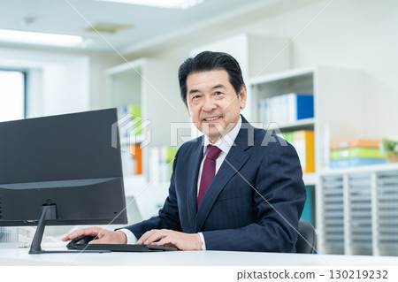 Senior businessman working in the office 130219232