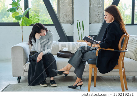 Sad stressed young woman patient talking with female psychologist, mental counselor 130219251