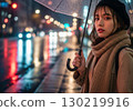 A Japanese woman wearing a beret holding an umbrella on a rainy night 130219916