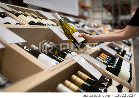 Woman's hands choosing wine Woman's hands choosing wine 130220227