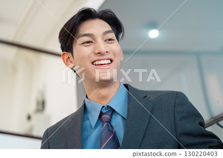 Smiling businessman in a suit, showcasing professionalism and confidence. Smiling businessman in a suit, showcasing professionalism and confidence. 130220403