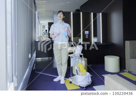 Full-body portrait of a young female office building cleaner. Photo courtesy of Tokyo Electronics College, Denpa Gakuen Corporation. 130220436