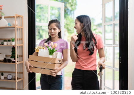 Moving in with friends, carrying flowers and boxes, celebrating new beginnings. 130220530