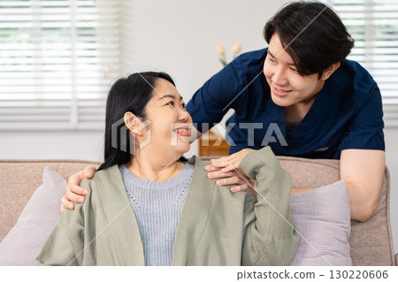 Friendly healthcare professional providing comfort and reassurance to a smiling patient during an in-home visit Friendly healthcare professional providing comfort and reassurance to a smiling patient during an in-home visit 130220606