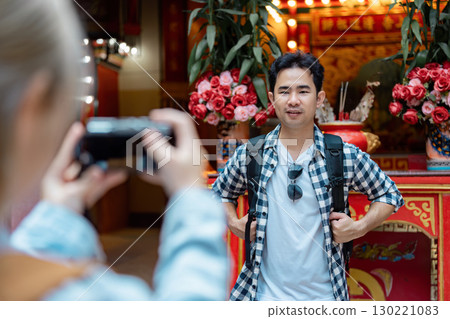 Young man posing for a photo in a vibrant cultural setting Young man posing for a photo in a vibrant cultural setting 130221083