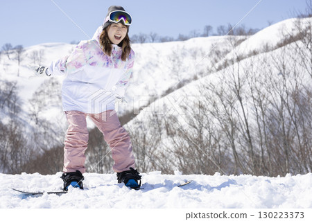 Cute woman enjoying snowboarding Cute woman enjoying snowboarding 130223373
